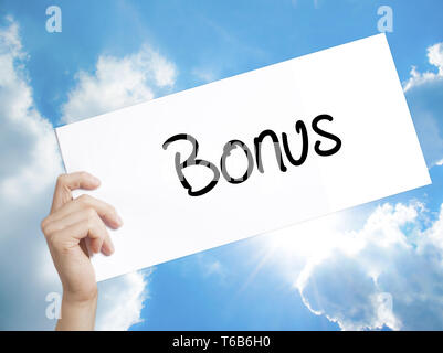 Segno di bonus su carta bianca. Man mano che tiene la carta con testo. Isolato su sfondo cielo Foto Stock