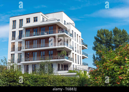 Moderno blocco di appartamenti con alberi e cespugli visto a Berlino, Germania Foto Stock