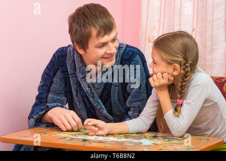 Padre e figlia guardato ogni altra raccolta di elementi di puzzle Foto Stock