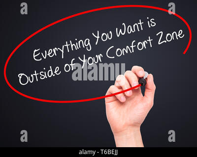 Man mano che scrive tutto ciò che si desidera è al di fuori della propria zona di comfort con pennarello nero su schermo visivo Foto Stock