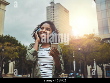 Giovane donna godendo ascoltando musica in cuffia Foto Stock