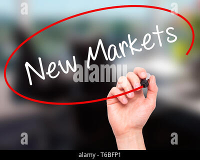 Man mano la scrittura di nuovi mercati con un pennarello nero su schermo visivo Foto Stock