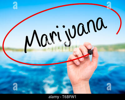 Man mano che scrive di Marijuana con pennarello nero su schermo visivo Foto Stock