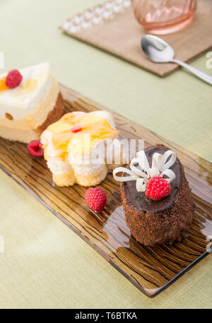 Gruppo di colorati gustose torte su piastra Foto Stock