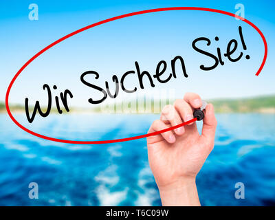 Man mano che scrive Wir suchen Sie! (Cercando Te in tedesco) con pennarello nero su schermo visivo Foto Stock