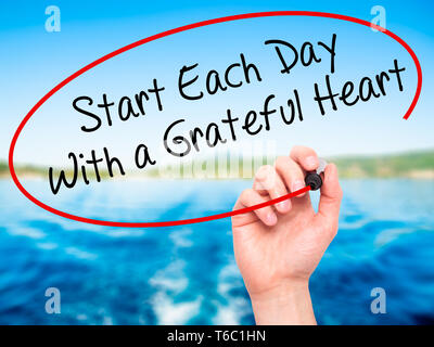 Man mano che scrive iniziare ogni giornata con un cuore grato con pennarello nero su schermo visivo Foto Stock