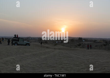 Tramonto nel deserto con peaople silhouette e jeep in Rajasthan in India Foto Stock