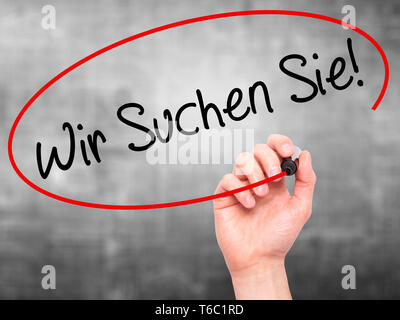 Man mano che scrive Wir suchen Sie! (Cercando Te in tedesco) con pennarello nero su schermo visivo Foto Stock