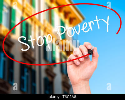 Man mano che scrive la povertà di arresto con il pennarello nero su schermo visivo Foto Stock