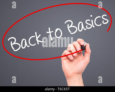 Man mano che scrive Back to basics con pennarello nero su schermo visivo Foto Stock