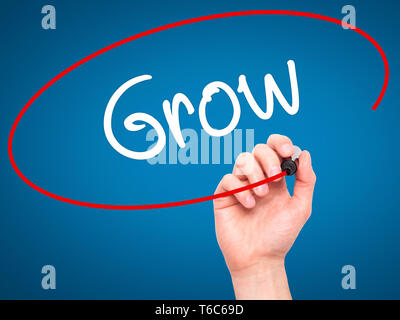 Man mano che scrive crescere con pennarello nero su schermo visivo Foto Stock