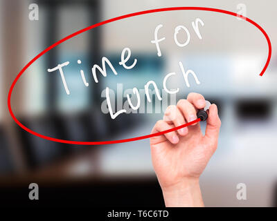 Man mano che scrive del tempo per il pranzo con il marcatore sul trasparente scheda di pulizia Foto Stock