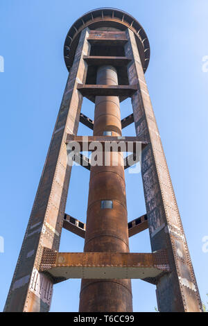 Vecchio arrugginito torre acqua e cielo blu chiaro Foto Stock