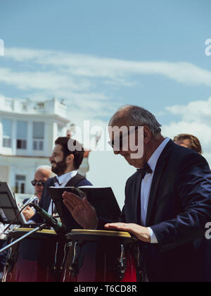 L'uomo gioca i tamburi del Congo, strumentali orchestra suona all'aria aperta di Batumi Georgia 2019 aprile 28 Foto Stock