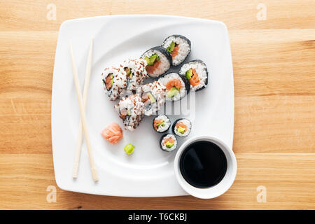 Il Sushi con salmone, avocado, riso nelle alghe marine serviti con wasabi e zenzero. Foto Stock