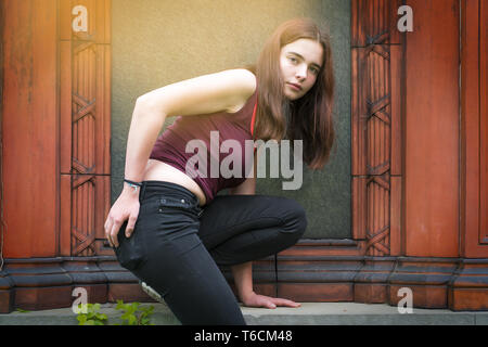 Ritratto di una giovane donna salendo una parete Foto Stock