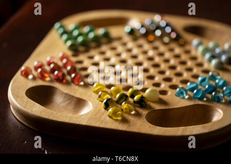 Un Cinese in legno gioco Dama a bordo con marmi di diverso colore, seduto su un legno di ciliegio tavolo. Foto Stock