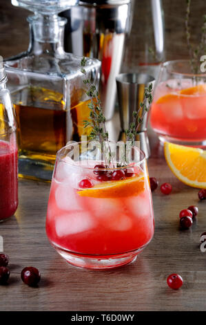 Cocktail a base di mirtillo palustre Bourbon arancione Smash con un suggerimento piccante di timo Foto Stock