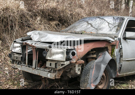 Abbandonato si è schiantato distrutto broken auto sulla strada di campagna Foto Stock