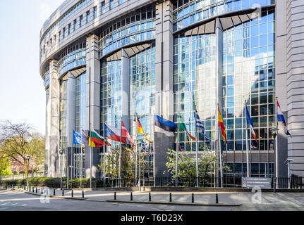 Il lato occidentale dell'edificio Paul-Henri Spaak, sede del l'emiciclo del Parlamento europeo a Bruxelles in Belgio, con le bandiere degli Stati membri. Foto Stock
