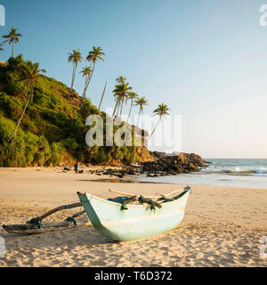 Barca di legno tradizionale Talalla sulla spiaggia al tramonto, South Coast, Sri Lanka, Asia Foto Stock