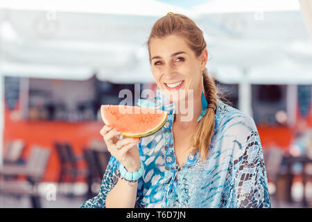 Donna che mantiene il pezzo di anguria Foto Stock
