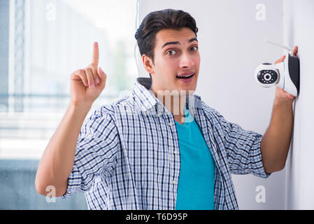 L'uomo installazione di sorveglianza telecamere TVCC a casa Foto Stock