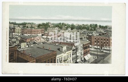 Cartolina a colori raffigurante un paesaggio urbano, da un angolo alto, della città di Port Huron, con le cime di mattone di edifici commerciali, case, alberi e una vista sia della St Clair di fiume o di Lago Huron visibile in distanza; situato a Port Huron, Michigan; con un copyright da Detroit Photographic Company, 1914. Dalla Biblioteca Pubblica di New York. () Foto Stock