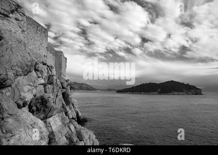 Città di mura difensive, stari grad, Dubrovnik, Croazia, dal Buža 2 bar: guardando a sud verso l'isola di Lokrum. Versione in bianco e nero Foto Stock