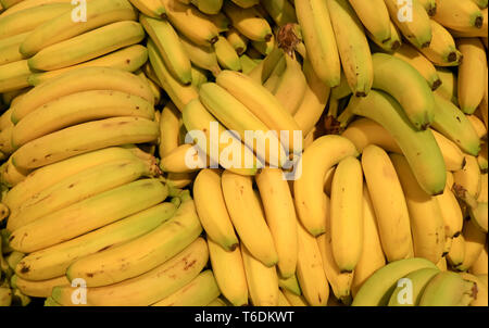 Pila di fresche e mature di vendita delle banane nel mercato Foto Stock