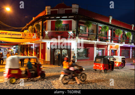 Honduras città; Street scene di notte con un tuk tuk e moto nella vivace città di Copan Ruinas, Honduras, America Centrale Foto Stock