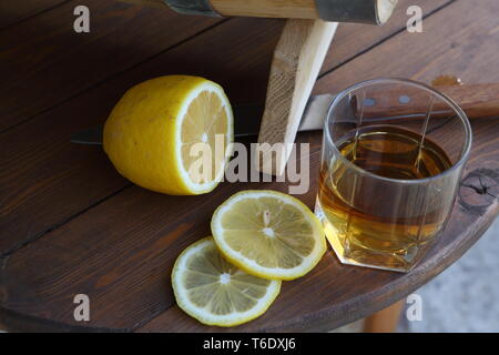 Un bicchiere di brandy con spicchi di limone vicino al barile Foto Stock