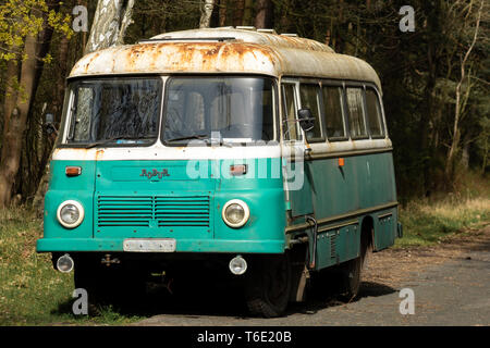 Vecchio arrugginito abbandonato 70s robur bus con una deliziosa luce vernice blu a sinistra in un legno isolata Foto Stock