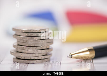 Valuta Euro monete impilate su dati e grafico Foto Stock