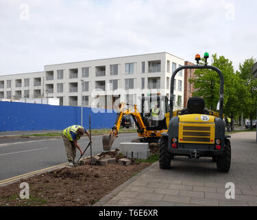 Aprile 2018 - lavoratori edili posa di cordoli di marciapiede accanto a una strada in Portishead, North Somerset, Regno Unito Foto Stock