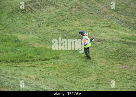 Tosaerba uomo nel parco della città Foto Stock