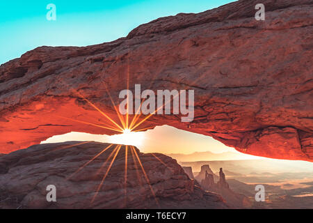 Sunburst, sunrise, attraverso la Mesa Arch nel Parco Nazionale di Canyonlands vicino a Moab, Utah, Stati Uniti d'America Foto Stock