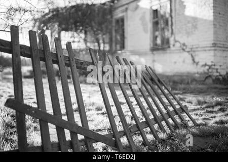 Vecchia staccionata in legno e country house in estate. Foto in bianco e nero Foto Stock