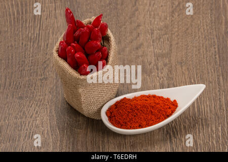 Polvere di peperoncino rosso su uno sfondo di legno Foto Stock