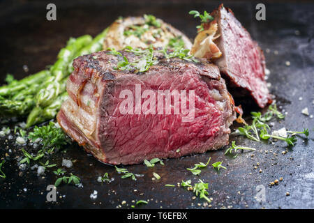 Barbecue punto Wagyu Steak con asparagi verdi e tappo a fungo come close-up su un arrugginito foglio di metallo Foto Stock