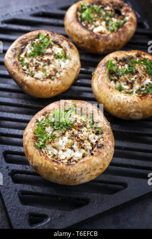 Italiani tradizionali tappi a fungo ripiene di formaggio feta come close-up su un grillage Foto Stock