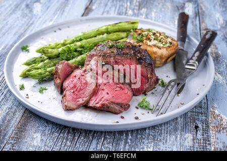 Barbecue punto Wagyu Steak con asparagi verdi e tappo a fungo come close-up su una piastra Foto Stock