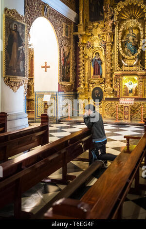 Uomo in ginocchio a pregare nella Basilica Cattedrale di Lima, Perù Foto Stock