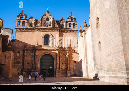 Una famiglia locale di entrare nel tempio della Sacra Famiglia sulla Plaza de Armas o piazza principale di Cusco, Perù Foto Stock