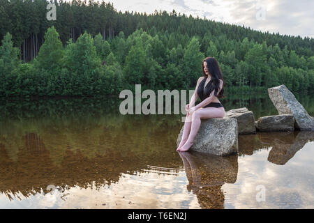 Bella ragazza in costume da bagno da un tranquillo tranquillo lago Foto Stock