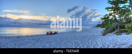 Tramonto sull'oceano sulla Spiaggia di Napoli con cieli bui tettuccio Foto Stock