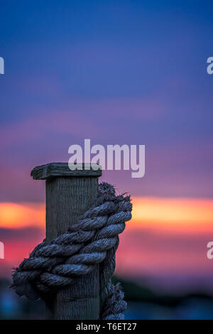 Spessore corda allacciate intorno a una recinzione di legno Foto Stock