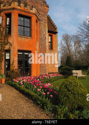 Chenies Manor House e Giardini in aprile mostra colorato tulip confini. Ritratto di aspetto Chenies Manor House nel sole refilato con tulip confini. Foto Stock