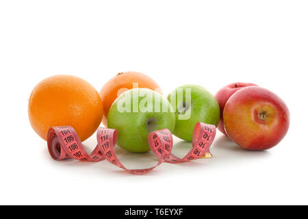 Frutti e nastro di misurazione su sfondo bianco. Cucina dietetica Foto Stock