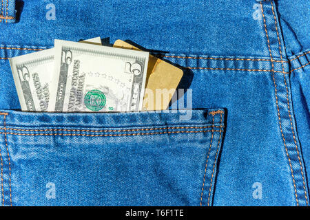 Credito Carta di plastica con dollari in contanti in tasca dei jeans Foto Stock